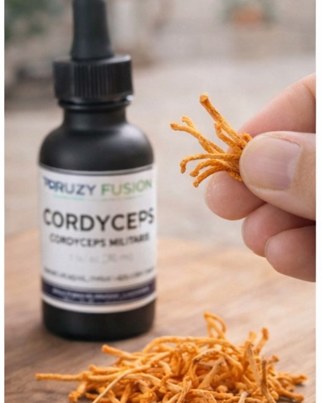 Bottle of 'Druzy Fusion Cordyceps' with dried cordyceps mushrooms on a wooden surface.